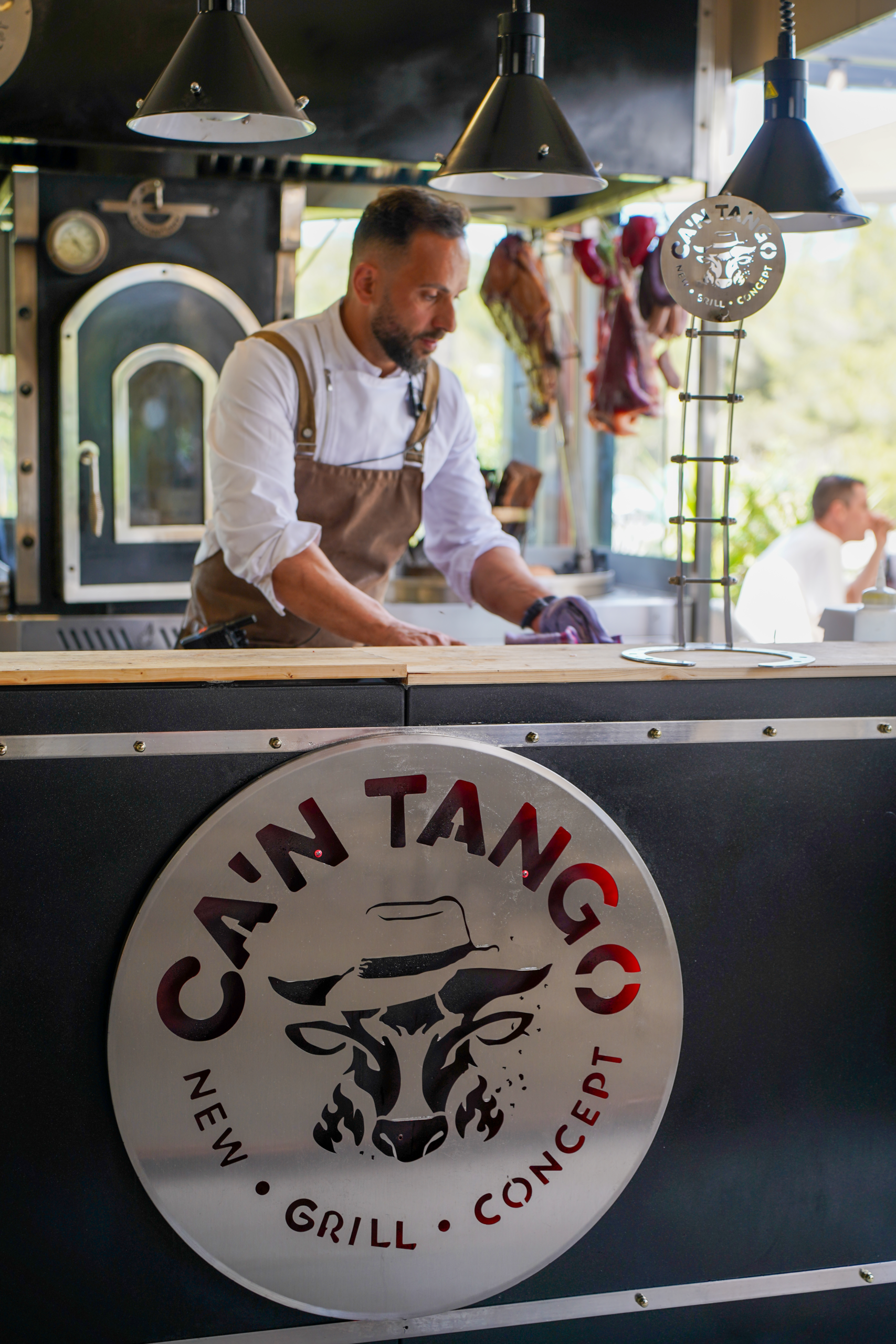 Ca'n Tango's open grill with cuts of meat roasting over wood in plain sight